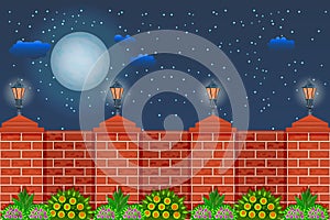 Fence against the night sky. Rural fence with pillars of red bricks, lamps, green plants and sky with moon, stars and clouds.