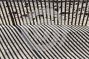 Fence at the beach gives a harmonic shadow