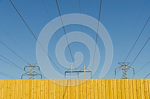 Fence with blue sky and power lines