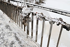 The fence of the bridge with the symbols of a strong marriage union, closed locks. Winter.