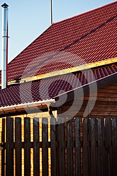 Fence, chimney,red tile of new wooden house