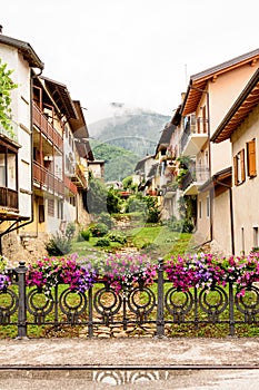 Fence decorated with flower vases in the Levico Terme , a village in the Italian Alps