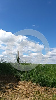 Fence on a farmland with a blue sky