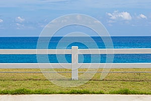 The fence on grassland and ocean view blue sky