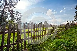 Fence in the green field under blue sky