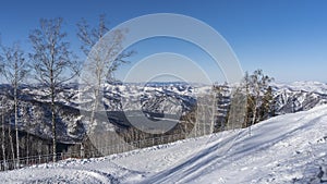 The fence is installed along the snow-covered hillside.