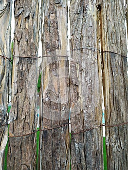 Fence made of tree bark slats and fastened with wire