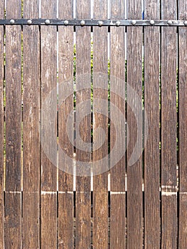 Fence made of vertical boards of natural wood