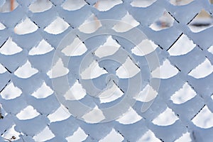 The fence from the metal gauze with cells the chain-link covered with snow