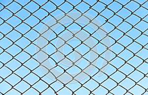 Fence of metal wire on a background blue sky