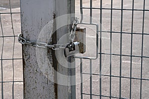 Fence: pole and padlock with chain to a fence with electro-welded metal grid in stainless steel.