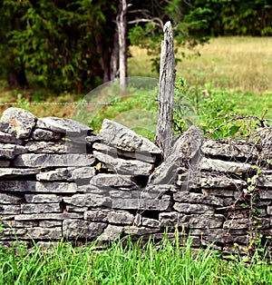 Fence Post Wedged Between Stones in Fence photo