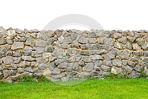 Fence real stone wall surface with cement on green grass field