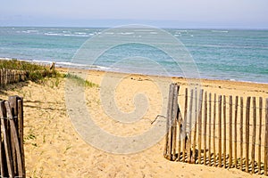Fence sea path way access Atlantic beach in sand dunes in isle oleron ocean france