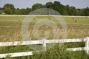 Fenced pastures and rolled hay bales