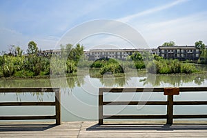 Fenced and planked lake shore in countryside on sunny summer day