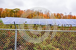 Fenced solar power plant on cloudy autumn day