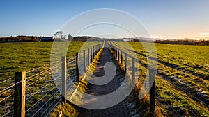 A fenced trail through agricultural land in the Scottish countryside in winter