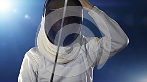 Fencer puts on mask and becomes fencing combat stance