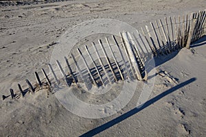 A fench covered with sand in the foreground