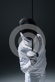In fencing mask holding rapier on