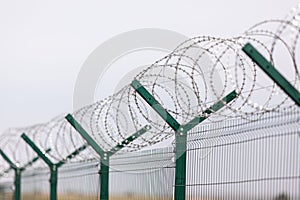 Fencing of sensitive sites with barbed wire. Barbed wire. Restriction of freedom. Prison fence. The concept of security