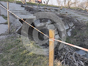 Fencing tape at the broken steps by the river on the dam.