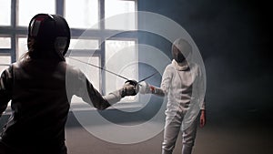 Fencing training - a woman pocking in her opponent with a sword