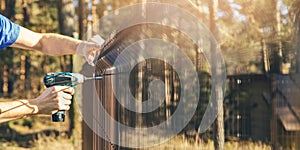 Fencing - worker installing metal wire mesh fence panel