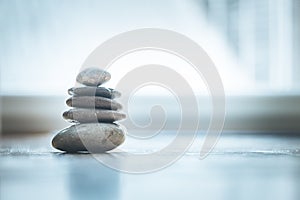 Feng Shui: Zen stones on the wooden floor, bright light is coming through the window