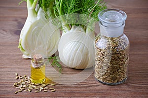 Fennel bulb and seeds, oil, selective focus on dark wooden