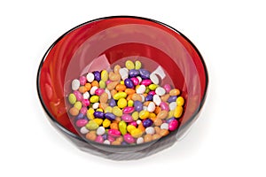 Fennel seed candy in a black bowl with reflections isolated over white