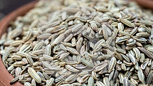 Fennel seeds in the clay bowl macro photography.
