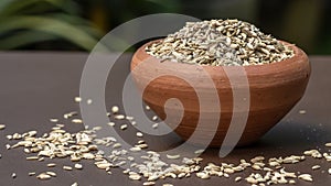 Fennel seeds in a small clay bowl on an old wooden table./ Fennel seeds over white background.