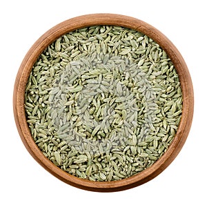 Fennel seeds in a wooden bowl over white