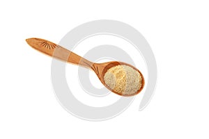 Fenugreek flour or Hulbah powder in wooden spoon on white background. Selective focus, copy space. Herbal nutritional supplement,