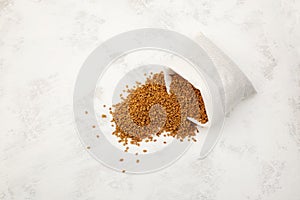 Fenugreek seeds spilled out of white pouch. Shambhala or helba is traditional Indian seasoning and ingredient Ayurvedic food.