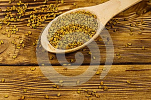 Fenugreek seeds in wooden spoon on wooden table