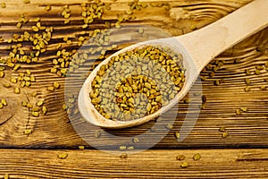 Fenugreek seeds in wooden spoon on wooden table