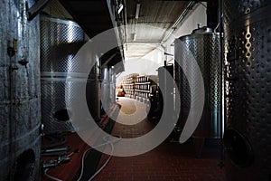 Fermentation tanks and barrels of wine in cellar in Santorini.