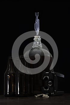 Fermented beer in a demijohn with airlock and hand capper with dark brown bottles and caps
