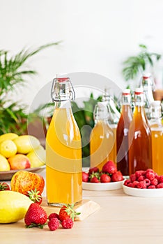 Fermented drink, kombucha in glass bottle with with fruits and Berries