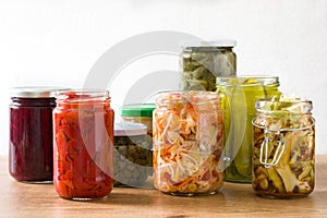 Fermented preserved vegetables in jar on wood photo