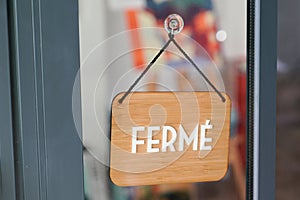 FermÃ© means in french closed boutique on wooden sign board wood on windows shop restaurant cafe store signboard