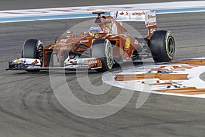 Fernando Alonso cornering a Ferrari F1 car at Yas Marina race track Abu Dhabi