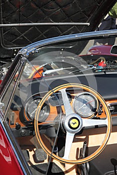 Ferrari steering wheel and dash board of front engined classic car.