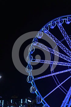 Ferries Wheel with colorful lights in dark sky, night time in amousement park