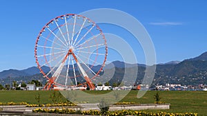 Ferris wheel in the afternoon against the backdrop of the mountains and the embankment of Batumi
