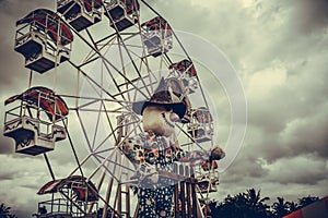 Ferris wheel against blue sky, vintage filter effects