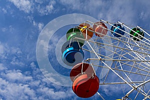 Ferris wheel against blue sky with white clouds